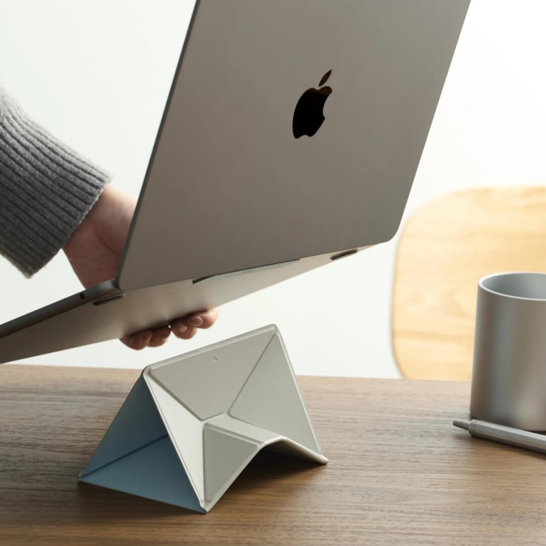 Portable fold-flat laptop stand being carried